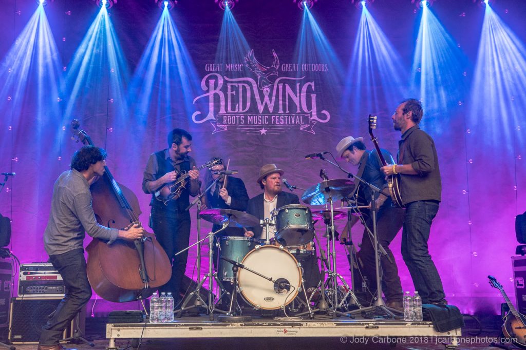 Steep Canyon Rangers band congregates around drummer during a song at Red Wing Roots Music Festival