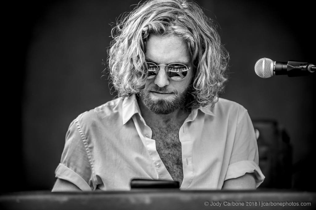 Ben White playing piano with reflection in sunglasses at Rooster Walk Music and Arts Festival