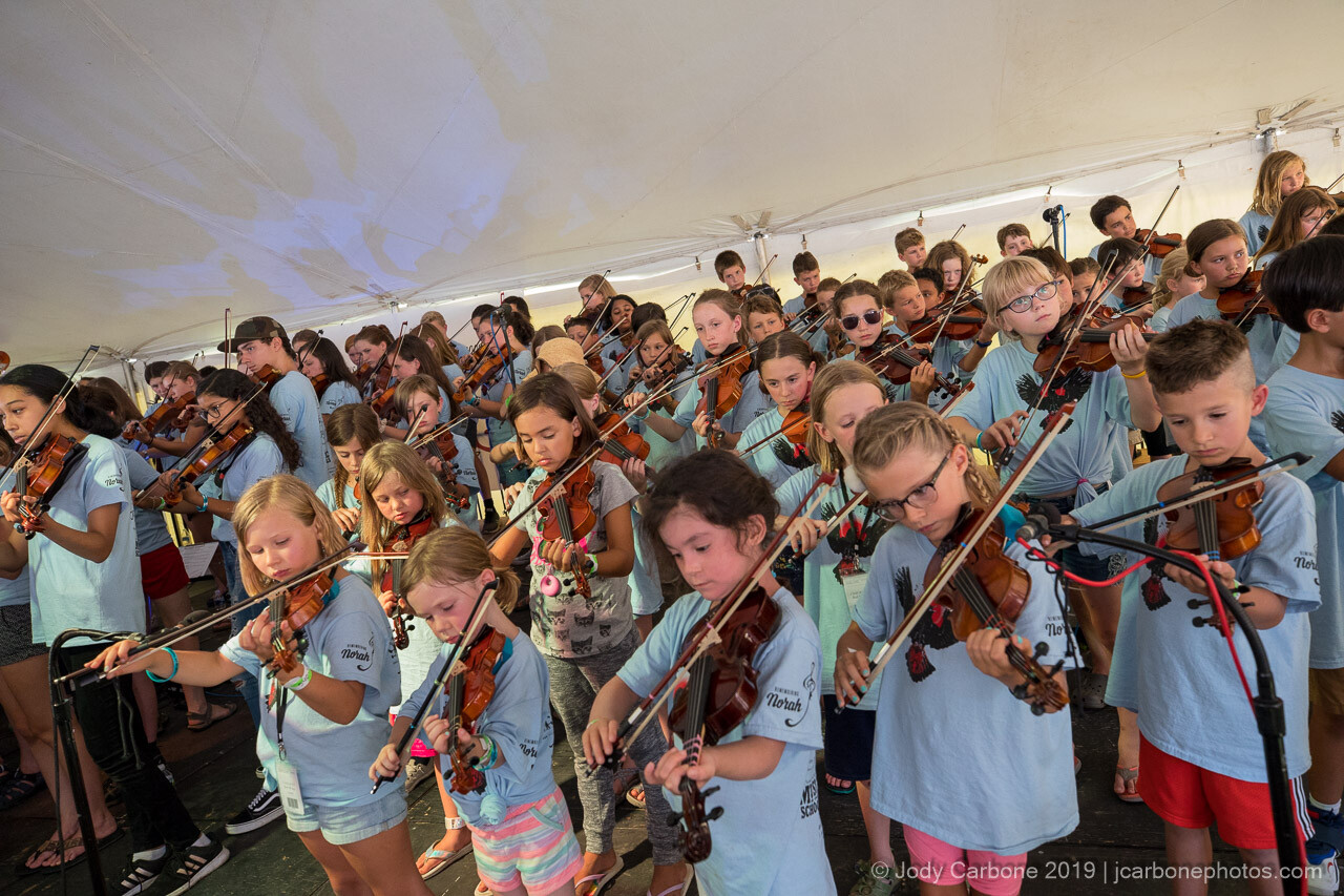 Children from Red Wing Academy playing violin and other instruments in their performance at Red Wing Roots Music Festival.