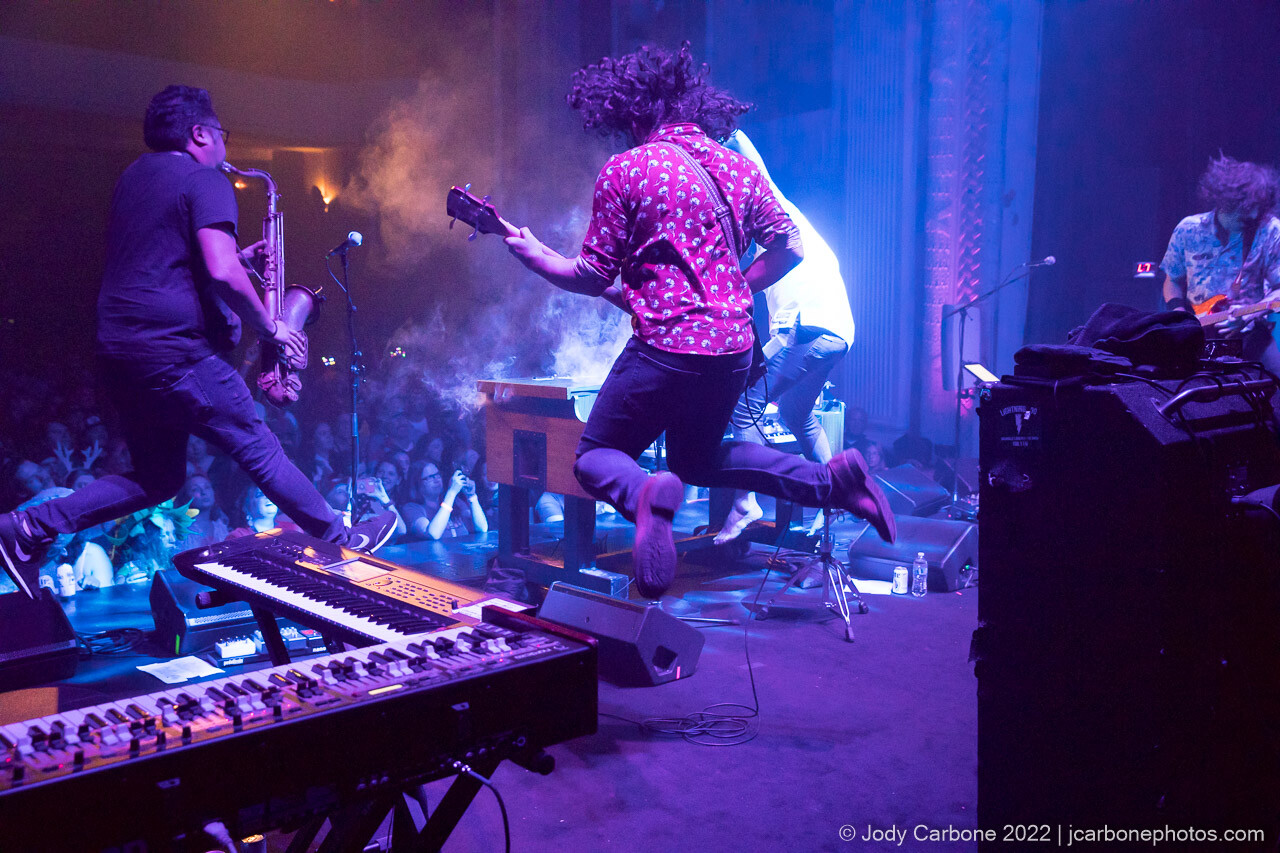Action concert photography - musicians jump high in the air with Andy Frasco