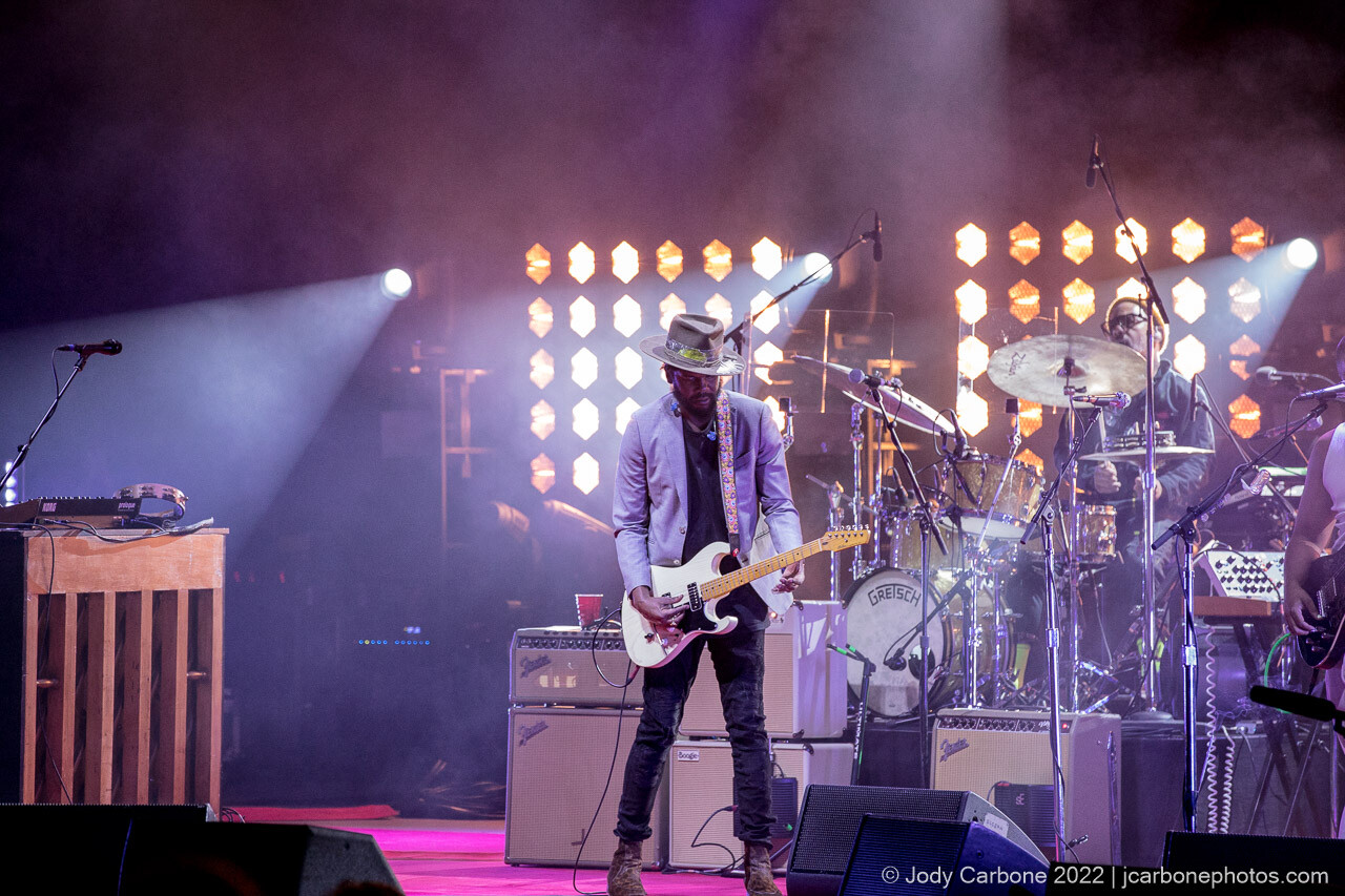 Gary Clark Jr. stands in front of his drummer while playing a guitar solo